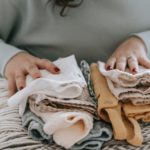 Woman with folded baby clothes